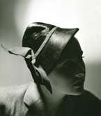 Porträtt av kvinna i svart panne-hatt med bandmontering av Claude S:t Cyr.