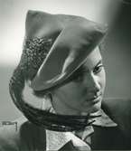 Porträtt av kvinna i senapsgul velourhatt med fasanfjädrar. Modell från Maison Gilbert Orcel.