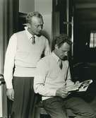 Två män läser en tidning. En av dem är Gert Fredriksson.