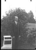 Bygdefotografen Hugo Bengtsson fotograferad på 50- årsdagen vid en trädgårdsstol i sin trädgård i Dämhult. Se även HB276. Se även HB275.