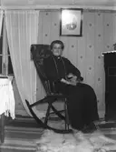 Interiörbild kvinna i gungstol, kvinnoporträtt.