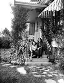 Artisten Mita Libell(till vänster) och en annan person sitter på en trappa.