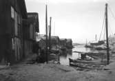 December 1923. Bryggparti, vinter med sjöbodar och båtar.