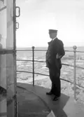 Mars 1924. Fyrmästaren Uhrberg stående på lanterninbryggan på Hållö fyr.