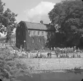 Hasselbackshuset och Bäveån, militärorkester till höger i bild.