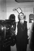 En biografmaskinist bredvid sin filmprojektor.