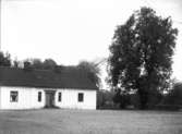 Kvinna vid flygelbyggnad, Strömsta säteri, Teda socken, Uppland, troligen 14 oktober 1909