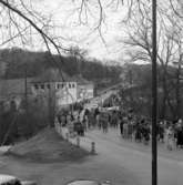 Första majdemonstration i Huskvarna år 1955. Nedför Stampabacken kommer folket tågande. En banderoll uppmanar 