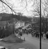 Första majdemonstration i Huskvarna år 1955. Nedför Stampabacken kommer folket tågande. En banderoll uppmanar 