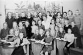 Fröken Elsa Spetz med elever (flickor: 10-11 år, fjärde året) på Centralskolan (senare Kvarnbyskolan) år 1946-47. Några sittandes i bänkar, resten stående bakom. 
Stående från vänster: Britt Jansson, Berit Larsson (givaren: född 1936, gift Gustafsson), Berit Parkström, Astrid Heijel, Margareta Widmer, Anita Norman, Gerd Karlsson, Siv Karlsson, Florence Edqvist, Lise-lott Reinel, Sisko Putkinen, Berit Åström.
2:a rad fr. vänster Gunnel Ellingdahl, Britt-Marie Andersson, Barbro Engström, Kerstin Henriksson, Gunnel Björstedt, Berit Pettersson, Fröken Elsa Spetz, Ulla Thorsson, Maj-Britt Magnusson, Margareta Wegnegård, Mona Jansson, Sonja Karlsson. Sittande fr. vänster Inger Andersson, Gunilla Stolpe, Siv Westerberg, Gull-Britt Pettersson?, Ingrid Andersson, Ingrid Andersson, Marinne Timell, Lena Belander, Birgit Magnusson och Marinne Fredriksén.
Fågelplanscher på väggen bakom.