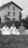 Tre kvinnor sitter på gräsmatta vid Kärra Hökegård, ett försörjningshem för såväl senildementa som psykiskt sjuka, personer för funktionsnedsättning och ensamstående mödrar. Verksamheten försvann i och med att Lackarebäckshemmet stod klart 1951.

Tidigare beskrivning: 