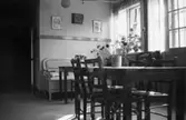 Rumsinteriör med matbord och stolar på Mölndals barnhem, (f. d. Holtermanska) Rudbergsgatan. Direktören Martin Holterman i Ostindiska kompaniet ägde Åby gård. 1782 skänkte han 3000 daler silvermynt till Fässbergs församling + ett nybyggt skolhus och trädgård på gårdens ägor vid Åby by. I skolan skulle 10 fattiga barn undervisas i 