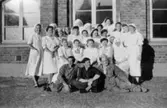Sjuksköterskor och tre män utanför Kvarnbyskolan 1945. Männen är  före detta koncentrationslägerfångar, förlagda till Kvarnbyskolan som då var karantänsförläggning.