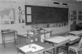 Ett klassrum med bänkar och svarta tavla. Dokumentation av Sagåsens flyktingförläggning, 1992.