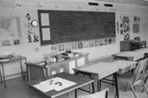 Ett klassrum med bänkar och svarta tavla. Dokumentation av Sagåsens flyktingförläggning, 1992.