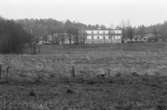 Sagåsens flyktingförläggning med ängsmark framför. Dokumentation av Sagåsens flyktingförläggning, 1992.