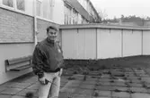 Dokumentation av Sagåsens flyktingförläggning 1992. En man står utomhus framför en byggnad. En bänk och insynsskydd finns i bakgrunden.