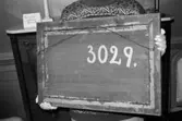 Antikvarisk storstädning på Gunnebo slott 1992. En person håller upp en tavla och visar baksidan, numrerat med 3029.