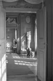 Dokumentationsbilder från Gunnebo slott våren 1992. Inredningsmiljö, konstföremål och möbler av varierande slag. Här ses en korridor av rum varav det mittersta har en staty och höga vaser.