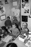 Barn som sitter på golvet och gör olika aktiviteter. Utställningsvernissage av och om Katrinebergs daghem på Mölndals museum 1993-09-10.