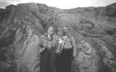 Ingrid Karlsson, Kerstin Karlsson (Astrids Garthmans syskon) och Ingrids fästman står lutandes mot en bergsknalle vid Näset, 1950-tal.