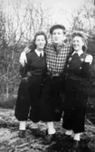 Charlie Jinnestedt håller om Elsa Jinnestedt till vänster och Astrid Garthman till höger. Fjärås Bräcka, 1940.