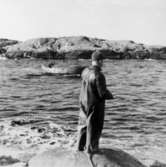 Helmer Garthman står på en klippa och fiskar. Näset, 1960-tal.