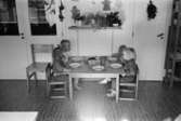 Fyra dagisbarn, bl. a. Pontus, Malin och Rebecka, sitter vid ett lågt bord och äter. Hoppetossan på Katrinebergs daghem 1992-93.