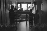 Interiör från Katrinebergs daghem. Man ser tre barn som står vid en matvagn. 1992-93.