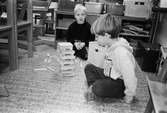 Två pojkar, vid Katrinebergs daghem, sitter inomhus på golvet och sätter ihop en byggsats av avlånga träbitar i miniformat. Hittills är modellen ca 20 cm - men vem vet hur hög den kan bli...