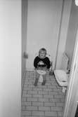 Ett litet barn sitter på toaletten i väntan på hjälp. Katrinebergs daghem, 1992-93.