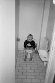 Ett litet barn sitter på toaletten i väntan på hjälp. Katrinebergs daghem, 1992-93.