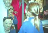En flicka tittar på pappersmasker vid spegeln. Familjesöndag på Mölndals Museum den 8/10 1995 under utställningen 