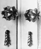 Ett par dörrhandtag och ett par nyckelskyltar av mässing till dubbeldörr i Östra förmaket. Gunnebo slott 1930-tal.