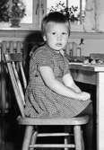 En flicka som sitter på en stol vid Holtermanska daghemmet 1953.
