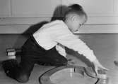 En pojke som leker med träklossar vid Holtermanska daghemmet 1953.
