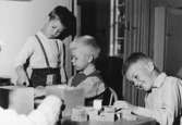 Tre pojkar som leker med byggklossar. Holtermanska daghemmet 1953.
