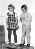 Två barn som står utefter en vägg inomhus. Holtermanska daghemmet 1953.