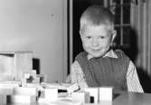 En leende pojke som leker med klossar. Holtermanska daghemmet 1953.