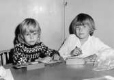 Två barn som sitter och ritar. Holtermanska daghemmet 1953.