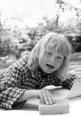 En flicka som håller en svamp och ett papper i händerna. Holtermanska daghemmet juni 1973.