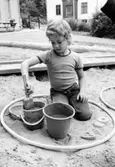 En pojke som leker i sandlådan. Holtermanska daghemmet 1973.