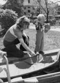 Ett barn och en fröken leker utomhus. Holtermanska daghemmet, okänt årtal.