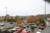 Vy från bron åt sydväst mot parkeringsplats (Koljan 4) och Storgatan. Mölndalsbro i dag - ett skolpedagogiskt dokumentationsprojekt på Mölndals museum under oktober 1996. 1996_1153-1171 är gjorda av högstadieelever från Kvarnbyskolan 9D, grupp 2. Se även 1996_0913-0940.