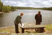 Sven Johansson, Inge Johansson och Lars-Erik Karlsson står vid ett bord brevid Hassungaredssjön år 1994.