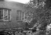 Kvarnfallet 31 i Grevedämmet, hösten 1994. Fabriksbyggnad i tegelsten vid vattendrag.