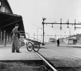 Chaufför Gustav Jarneving på väg att möta tåg 4101, som kommer till
Eskilstuna C. kl 05.59 med stockholmstidningarna. Postbilen finns
parkerad utanför järnvägsstationen.