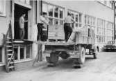 Pallarna med tidningsbuntarna lastas på lastbil, vid ICA-Kuriren,
f.v.b. till järnvägen.