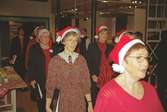 Julklädd kör sjunger på museet