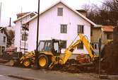 Grävmaskin vid Lyktplatsen, som håller på att iordningställas, april 1993. Bostadshuset i bakgrunden ligger på Götaforsliden 4.